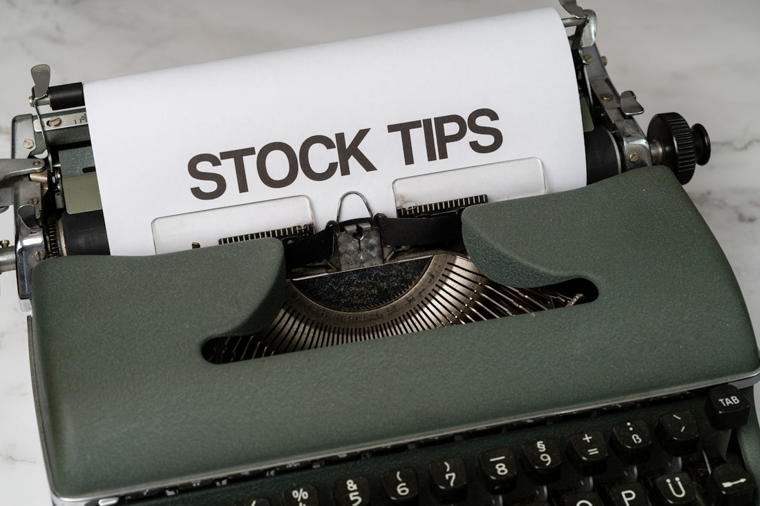 a close up of an old fashioned typewriter with a paper that reads stock tips